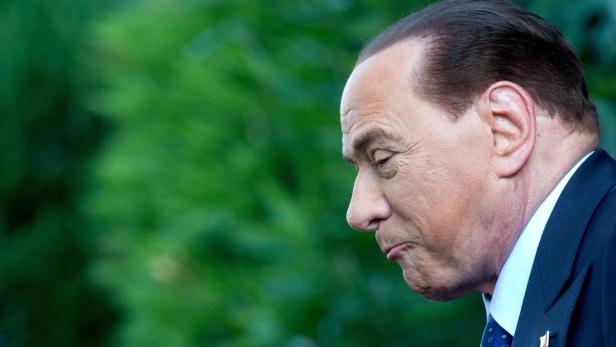 Silvio Berlusconi im Profil vor einem grünen Hintergrund.