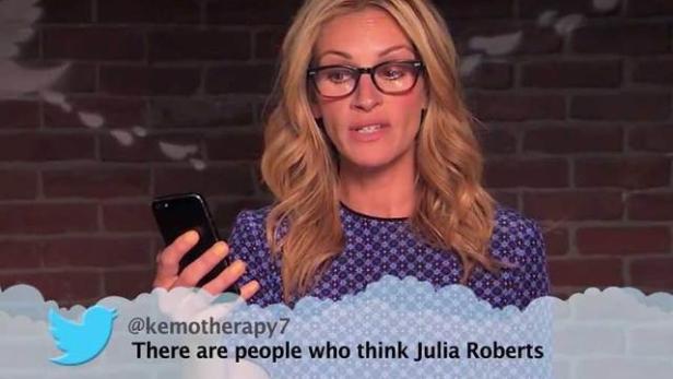 Julia Roberts mit Brille hält ein Smartphone in der Hand.