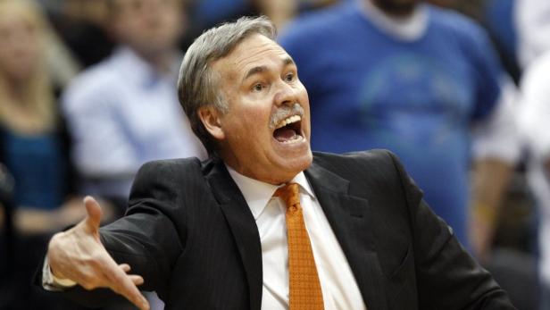 Ein Basketballtrainer gestikuliert aufgeregt mit geöffnetem Mund.