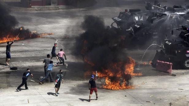 Bei einer Demonstration bewerfen Demonstranten Wasserwerfer mit Molotowcocktails.