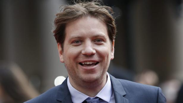 Tim Heidecker lächelt in einem blauen Anzug.