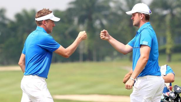 Zwei Golfspieler stoßen mit den Fäusten aneinander.