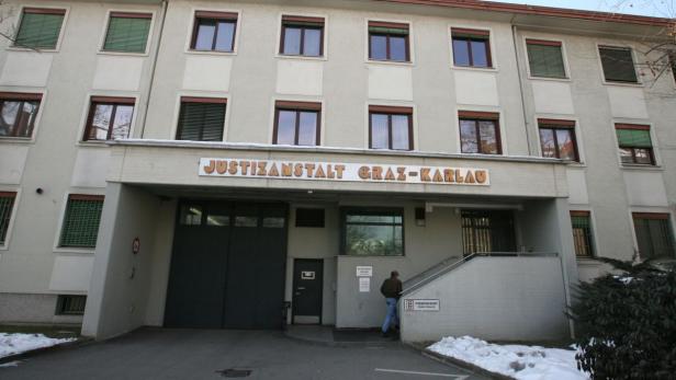 Die Justizanstalt Graz-Karlau mit einem Mann, der die Treppe zum Eingang hochgeht.
