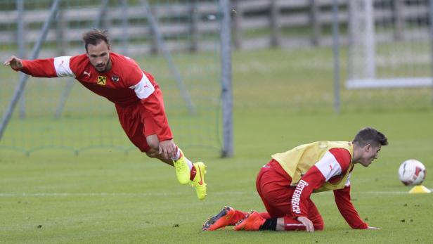 Zwei österreichische Fußballspieler trainieren auf einem grünen Rasen.
