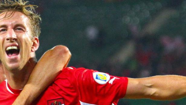Zwei jubelnde Fußballspieler im roten Trikot der österreichischen Nationalmannschaft.