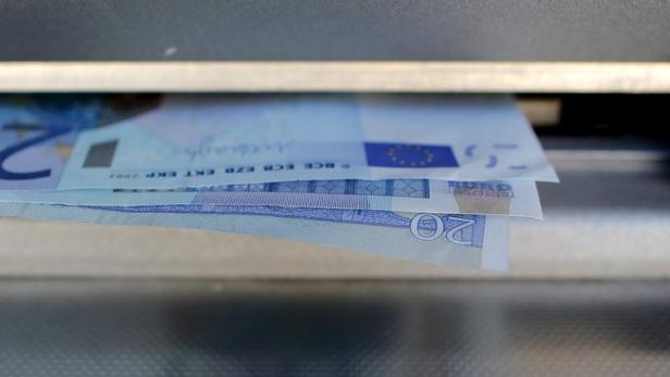 Ein Stapel 20-Euro-Scheine kommt aus einem Geldautomaten.