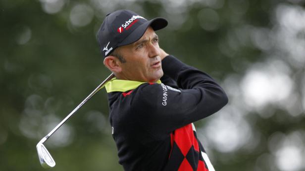 Ein Golfspieler schwingt seinen Schläger auf einem Golfplatz.