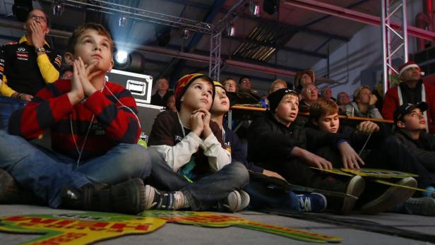 Eine Gruppe von Kindern und Erwachsenen schaut aufmerksam auf eine Leinwand.