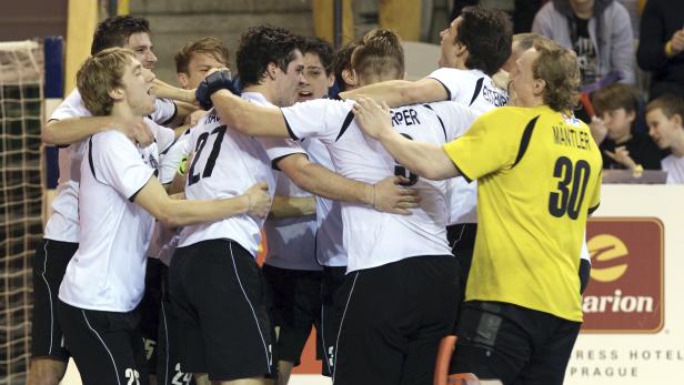 Eine Gruppe von Hockeyspielern umarmt sich auf dem Spielfeld.