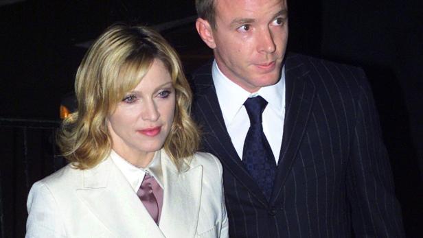 US pop star Madonna arrives with her husband film director Guy Ritchie at the National Portrait Gallery in London January 29 2002. The couple were attending the launch of an exhibition by celebrity photographer Mario Testino. REUTERS/Kieran Doherty