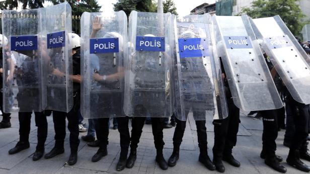 Eine Reihe Polizisten stehen mit Schilden in einer Reihe.