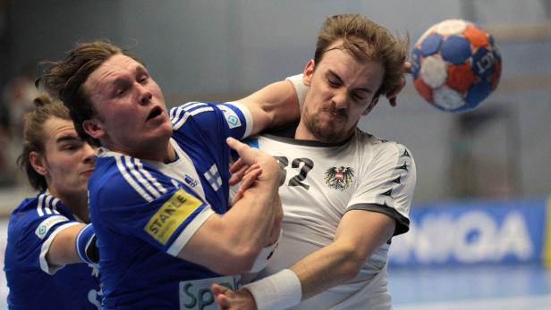 Ein Handballspieler blockt einen anderen während eines Spiels.