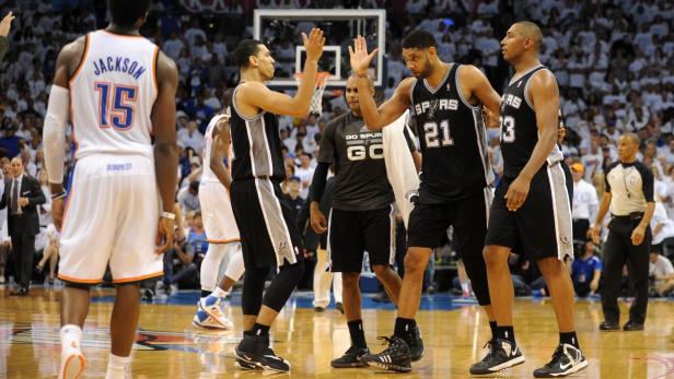 Basketballspieler geben sich während eines Spiels High-Fives.
