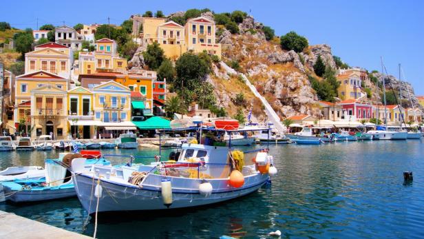 Scenice Greek harbor… Ausflüge führen u. a. zur imposanten Festung von Lindos und zur kleinen Schwammtaucherinsel Symi (Bild) mit ihren bunten Häusern.
