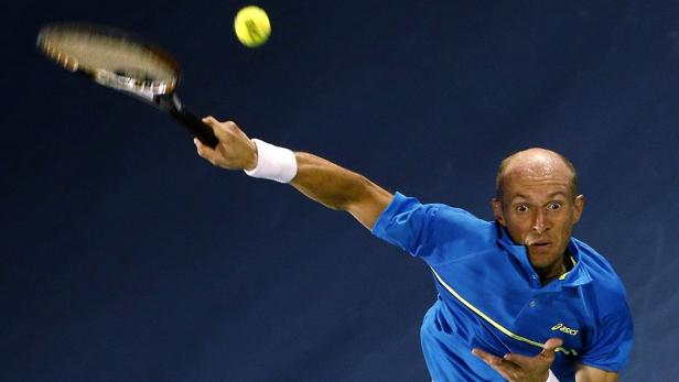 Ein Tennisspieler schlägt einen gelben Tennisball mit seinem Schläger.