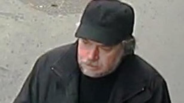 Ein Mann mit Bart und schwarzer Kappe blickt nach unten.