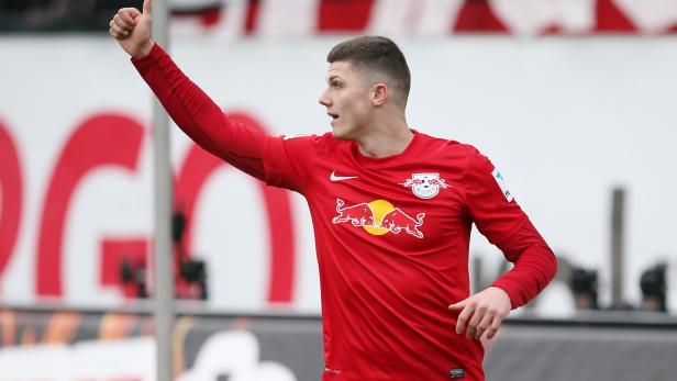 Ein Fußballspieler im roten Trikot von RB Leipzig zeigt den Daumen nach oben.