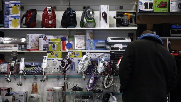 Ein Mann steht vor einem Regal mit Haushaltsgeräten in einem Geschäft.