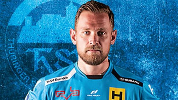 Ein Mann im Sporttrikot des ThSV Eisenach vor blauem Hintergrund.