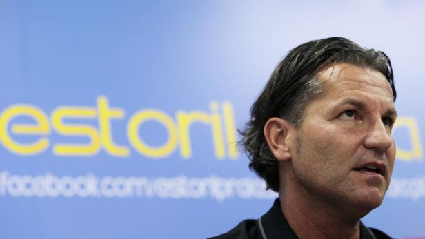 Ein Mann vor einem blauen Hintergrund mit dem Schriftzug „estoril“.