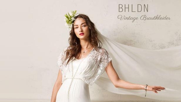 Eine Frau mit Blumenkranz trägt ein Vintage-Brautkleid von BHLDN.