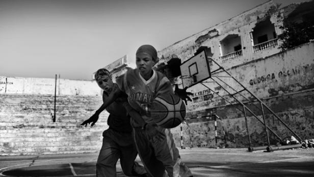 Zwei junge Frauen spielen Basketball auf einem beschädigten Platz in Somalia.