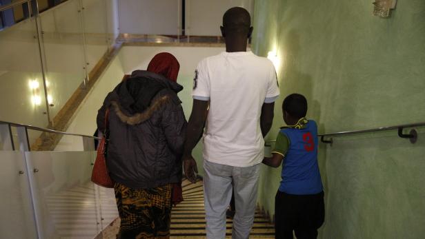 Ein Mann, eine Frau und ein Kind gehen eine Treppe hinunter.