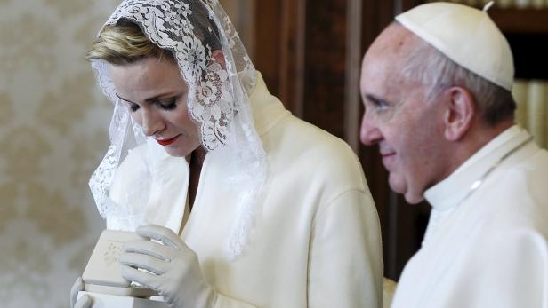 Princess Charlene (L) exchanges gifts with Pope Francis during a private audience with her husband Prince Albert II of Monaco (unseen) at the Vatican, January 18, 2016. REUTERS/Filippo Monteforte/Pool TPX IMAGES OF THE DAY