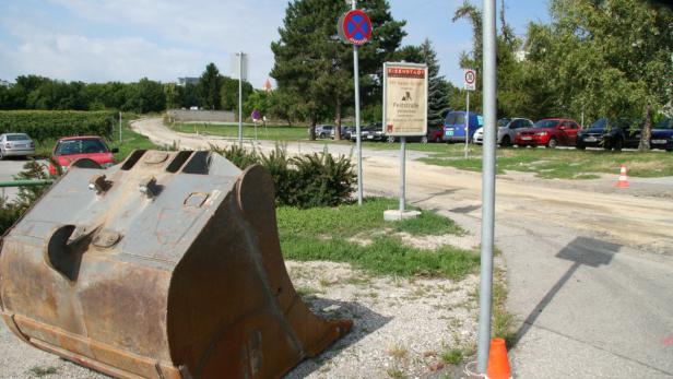 Ein Baggerlöffel liegt neben einer Baustelle in Eisenstadt.