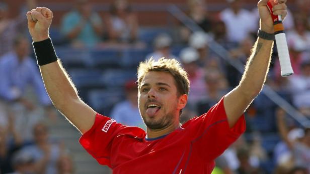 Stan Wawrinka jubelt mit erhobenen Armen und herausgestreckter Zunge.