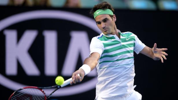 Roger Federer schlägt einen Tennisball vor einem Kia-Logo.