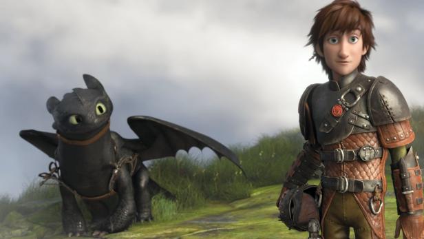Hicks und Ohnezahn, der Drache, stehen zusammen in einer grünen Landschaft.