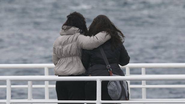 Relatives of victims embrace themselves during a ceremony to commemorate the first anniversary of the Costa Concordia shipwreck, in which 32 people died, outside Giglio harbour January 13, 2013. REUTERS/Tony Gentile (ITALY - Tags: DISASTER MARITIME ANNIVERSARY)