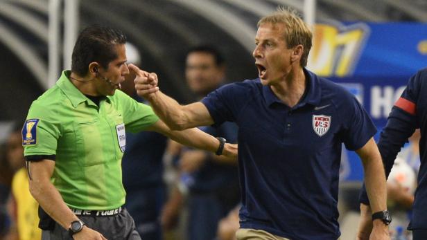 Jürgen Klinsmann gestikuliert auf einen Schiedsrichter während eines Fußballspiels.