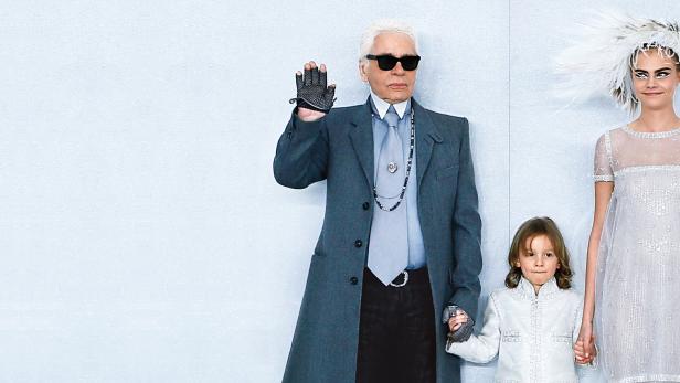 Karl Lagerfeld mit Cara Delevingne und einem Kind bei einer Modenschau.