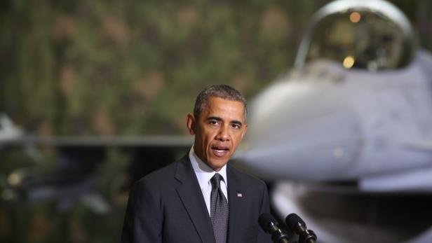 Barack Obama spricht vor einem Kampfjet.