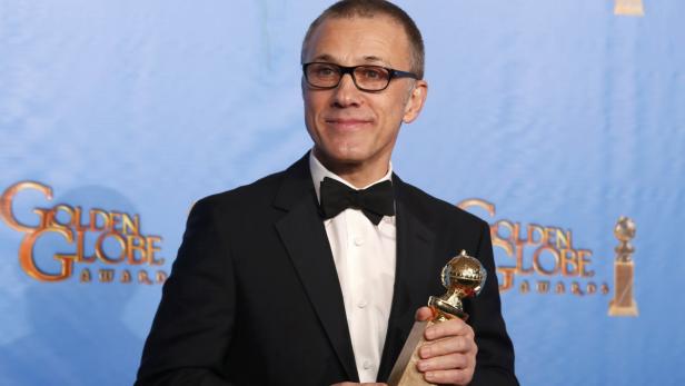 Christoph Waltz hält eine Golden Globe Trophäe in der Hand.