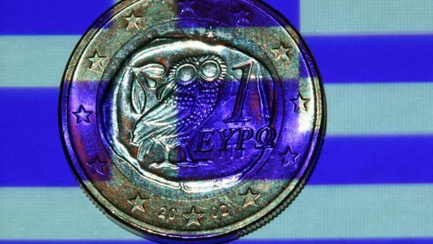 epa03316193 An illustration showing a Greek flag projected onto a Greek one euro coin in Schwerin, Schwerin, Germany, 24 July 2012. International creditors will on 24 review Greece&#039;s troubled austerity programme at a time of renewed concern about the country&#039;s future in the eurozone. The new conservative-led coalition government is scrambling to come up with 2.5 billion euros (3 billion dollars) more in savings to meet the target of 11.5 billion euros set by the European Union and the International Monetary Fund (IMF) for 2013 and 2014. Among the measures recommended by the Center of Planning and Economic Research (KEPE) pension cuts worth an estimated total of 5.1 billion euros. EPA/JENS BUETTNER