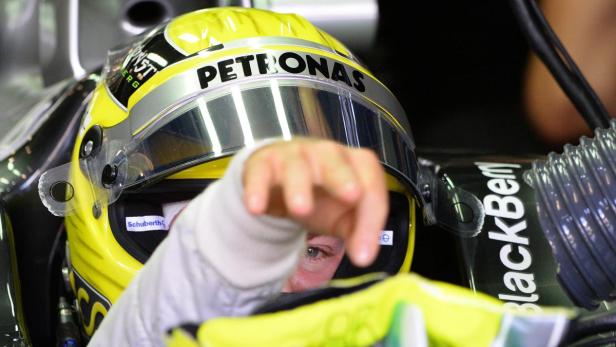 Ein Formel-1-Fahrer mit gelbem Helm der Marke Schuberth und Petronas-Aufschrift im Cockpit.