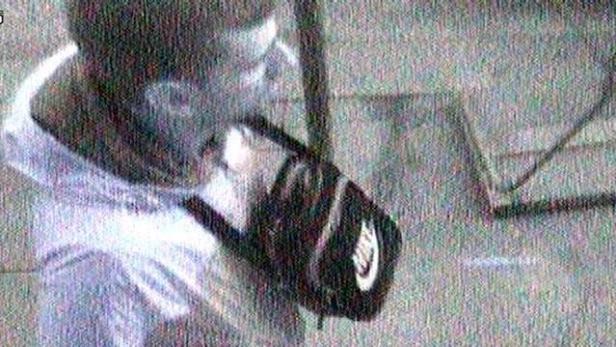 Eine Person mit einer schwarzen Nike-Tasche über der Schulter.