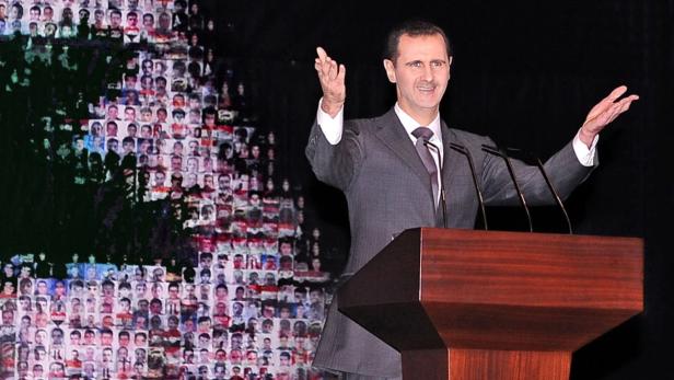 epa03526208 A handout photograph made available by the official Syrian Arab News Agency (SANA) shows Syrian President Bashar Al Assad delivering a speech, behind him is a Syrian flag made of pictures of people allegedly killed during the uprising, in Damascus, Syria, 06 January 2013. Assad, in his first public remarks since November, ruled out dialogue with opposition groups he called &#039;puppets&#039; of the West and vowed to continue battling &#039;terrorists&#039; and &#039;gangsters&#039; fighting to overthrow his regime. EPA/SANA\HANDOUT CROPPED VERSION OF epa03526191 HANDOUT EDITORIAL USE ONLY/NO SALES