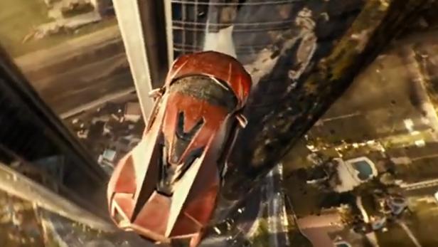 Ein rotes Auto rast aus einem zerstörten Hochhaus in die Tiefe.