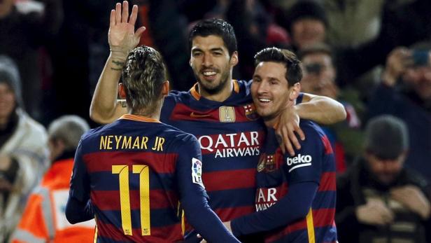 Neymar Jr., Luis Suárez und Lionel Messi feiern zusammen auf dem Fußballplatz.
