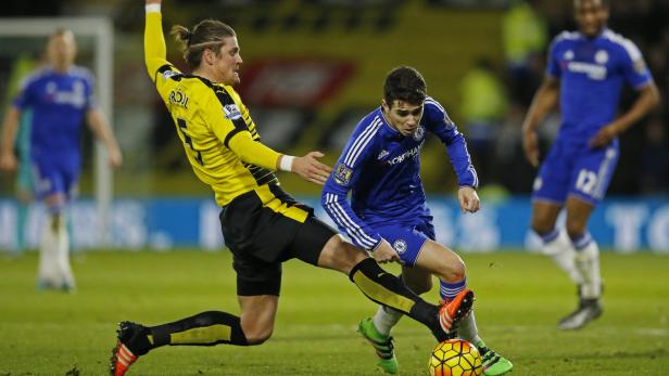 Zwei Fußballspieler kämpfen um den Ball auf dem Spielfeld.