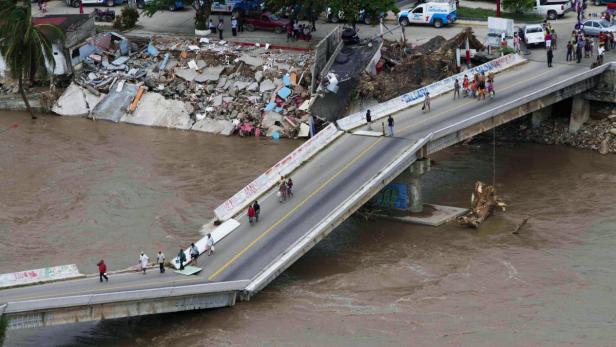 An aerial view shows people walking on a collapsed
