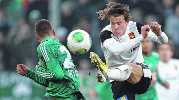 Ein Fußballspieler schießt den Ball während eines Spiels.