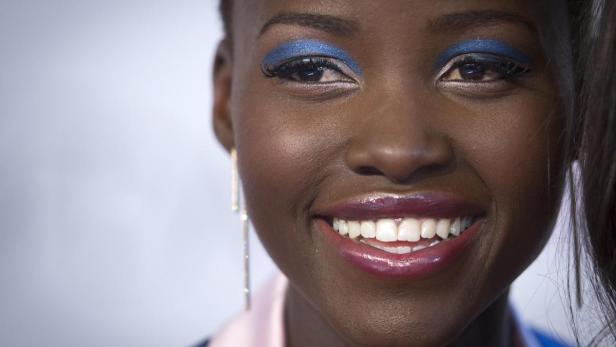 Nahaufnahme von Lupita Nyong'o mit blauem Lidschatten und glänzendem Lippenstift.