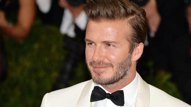 David Beckham trägt einen weißen Anzug mit Fliege.
