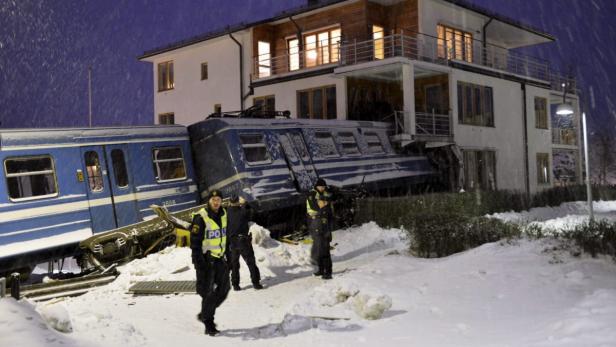 epa03536501 Swedish police at the scene after a local train embedded itself in a residential house after being derailed in Saltsjoebaden outside Stockholm, Sweden, 15 January 2013. Reports state that no resident in the building was injured in the accident. EPA/JONAS EKSTROEMER SWEDEN OUT