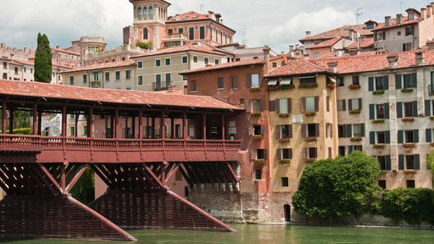Die hölzerne Ponte Vecchio Brücke in Bassano del Grappa überspannt das grüne Wasser des Flusses Brenta.